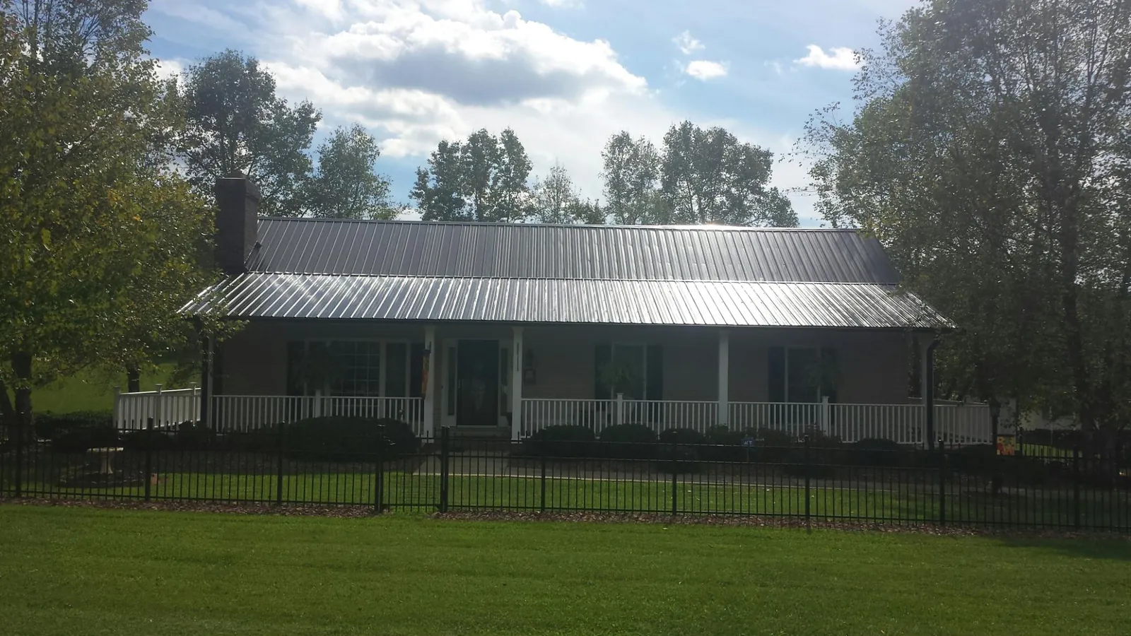 Gray metal roof on a brick ranch with a full width front porch — Gutter Guard Installation work by our crew in Rancho Mirage